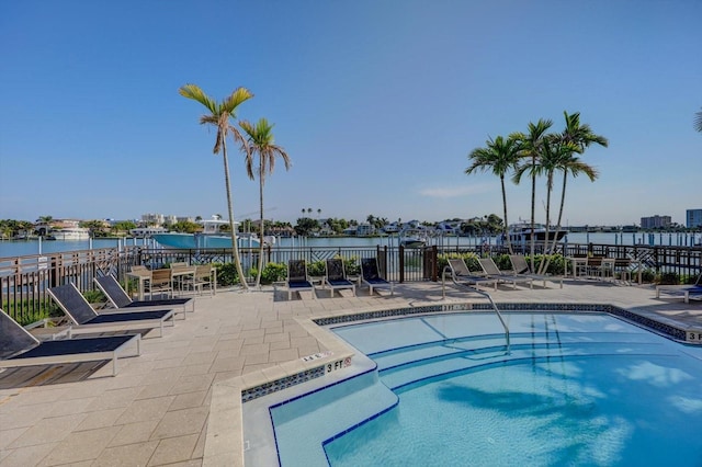 view of pool with a patio and a water view