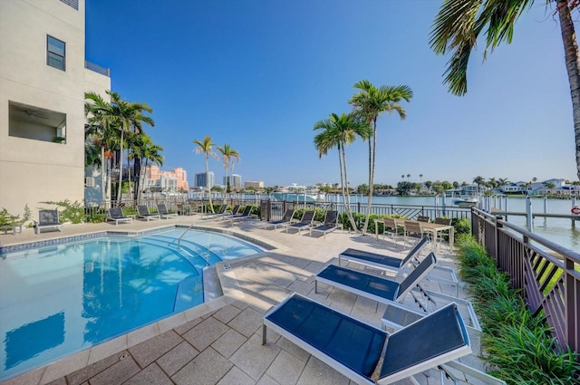 view of pool with a water view and a patio area