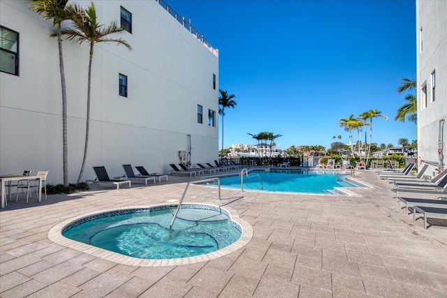 view of swimming pool featuring a community hot tub and a patio