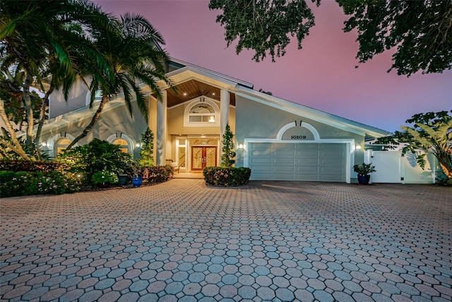 view of front of house featuring a garage, decorative driveway, and stucco siding