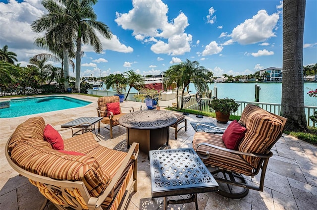 view of pool featuring a water view, a patio area, and an outdoor fire pit