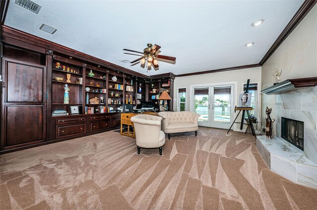 sitting room featuring a fireplace, french doors, light colored carpet, ceiling fan, and ornamental molding