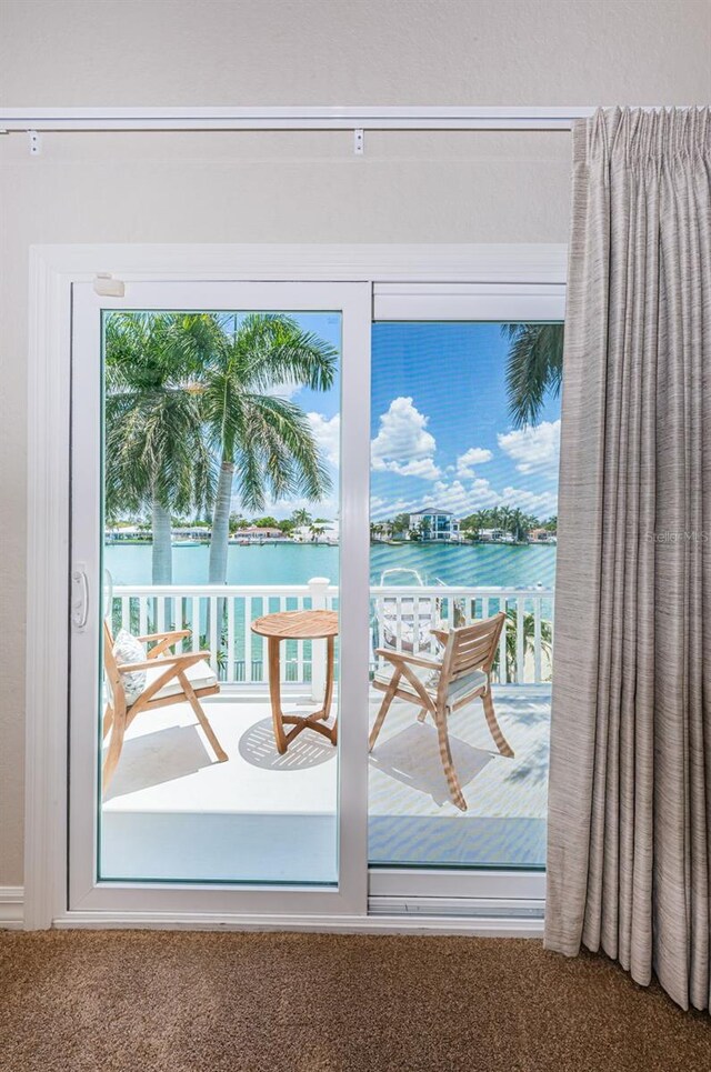 doorway featuring a water view and carpet