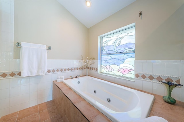 bathroom with vaulted ceiling, tile walls, a wealth of natural light, and tile patterned flooring