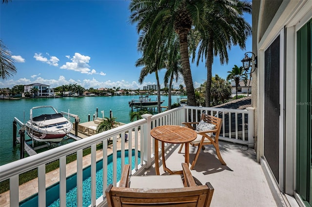 balcony with a water view and a boat dock