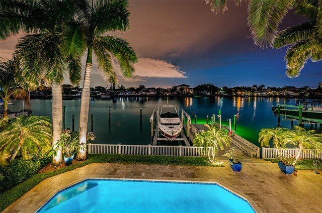 pool at dusk featuring a dock and a water view