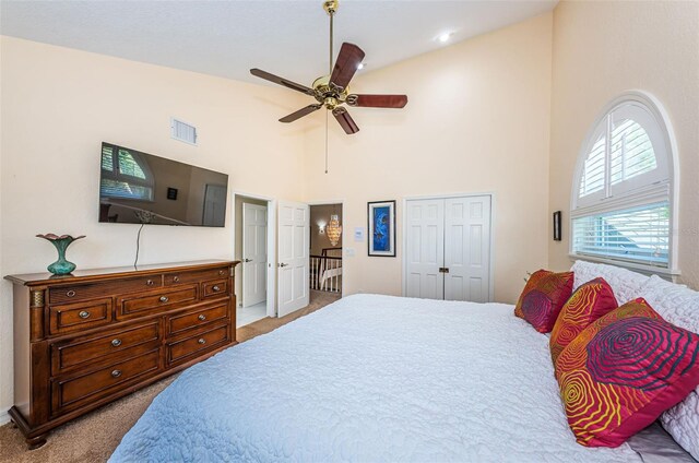 carpeted bedroom featuring a closet, ceiling fan, and high vaulted ceiling