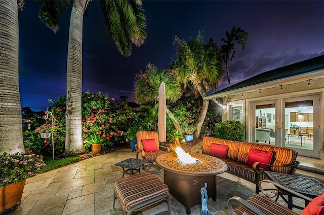 patio at twilight featuring an outdoor living space with a fire pit