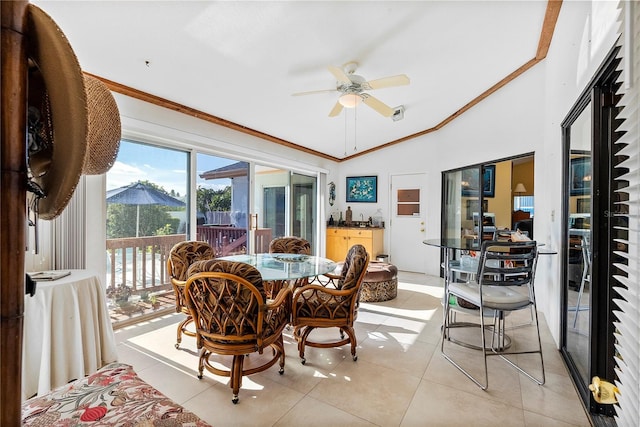 tiled dining room with crown molding, ceiling fan, and lofted ceiling