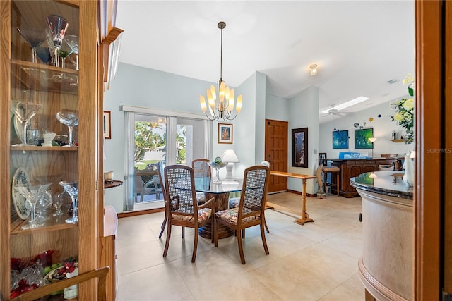 dining space featuring ceiling fan with notable chandelier, vaulted ceiling, and light tile patterned floors