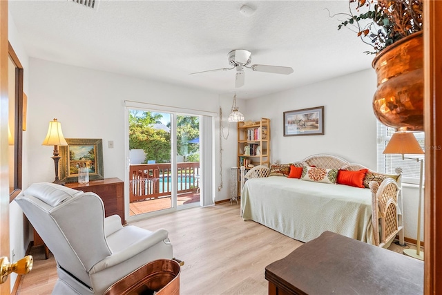 bedroom with light wood-type flooring, access to outside, and ceiling fan