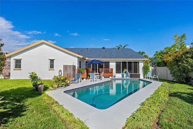 back of house featuring a fenced in pool and a lawn