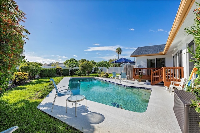 view of swimming pool with a patio area, a lawn, and a deck