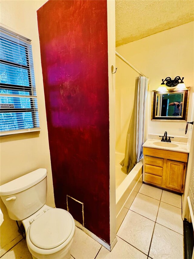 bathroom featuring a shower with shower curtain, vanity, tile patterned flooring, and toilet