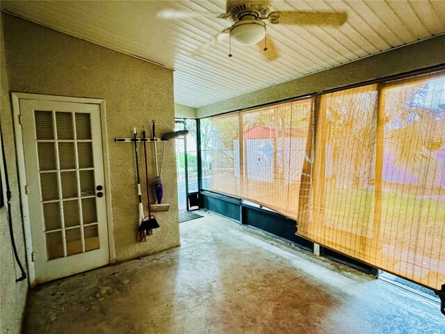 unfurnished sunroom featuring ceiling fan