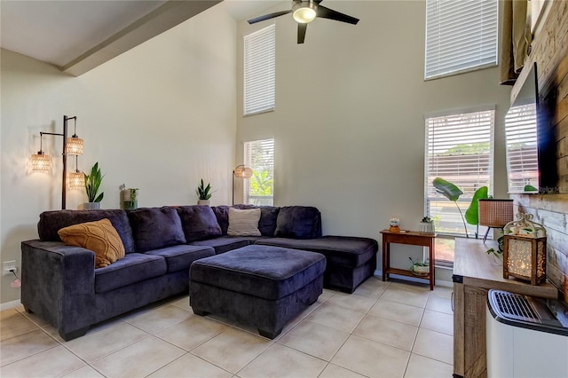 tiled living room with a high ceiling, a wealth of natural light, and ceiling fan