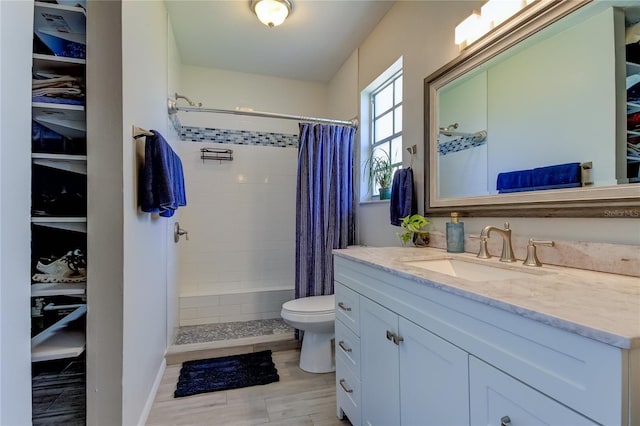 bathroom featuring a shower with shower curtain, vanity, and toilet