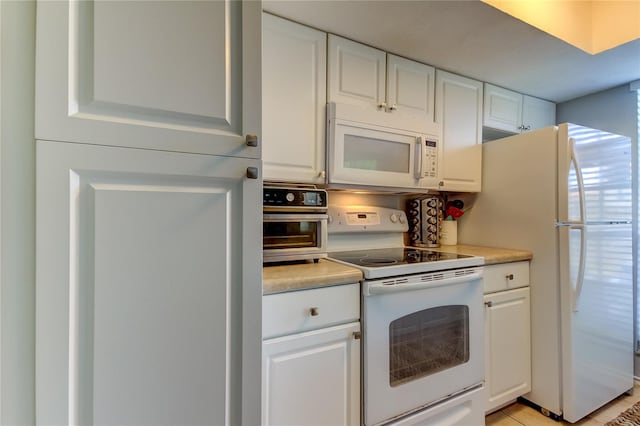 kitchen featuring white cabinets and white appliances