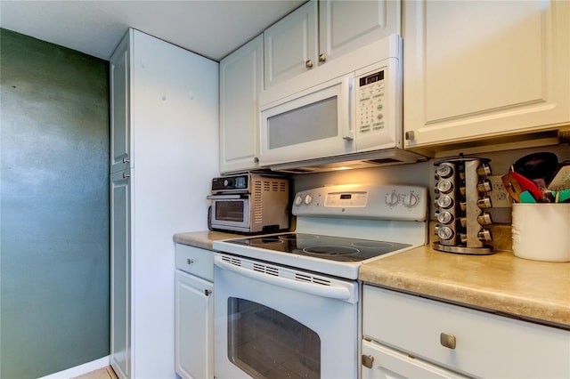 kitchen featuring white cabinets and white appliances