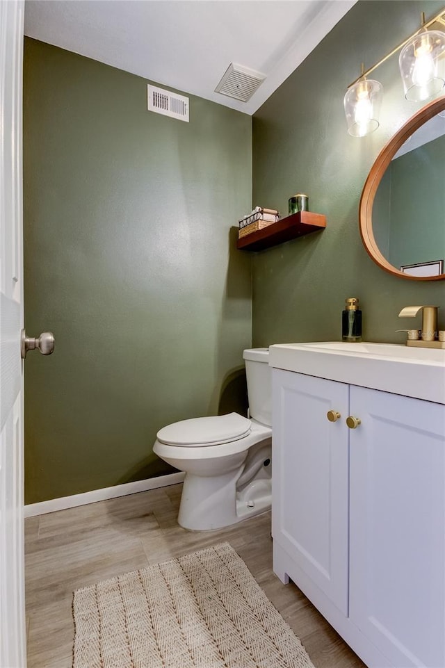 bathroom featuring vanity, hardwood / wood-style flooring, and toilet