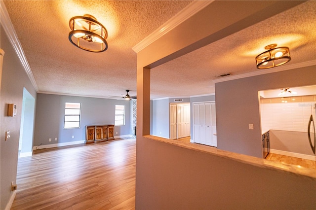 interior space featuring a textured ceiling, crown molding, and hardwood / wood-style floors