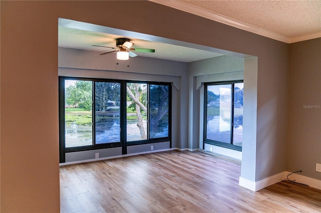 empty room with ceiling fan, crown molding, light wood-type flooring, and a textured ceiling