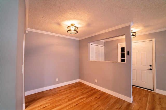 unfurnished room with crown molding, wood-type flooring, and a textured ceiling