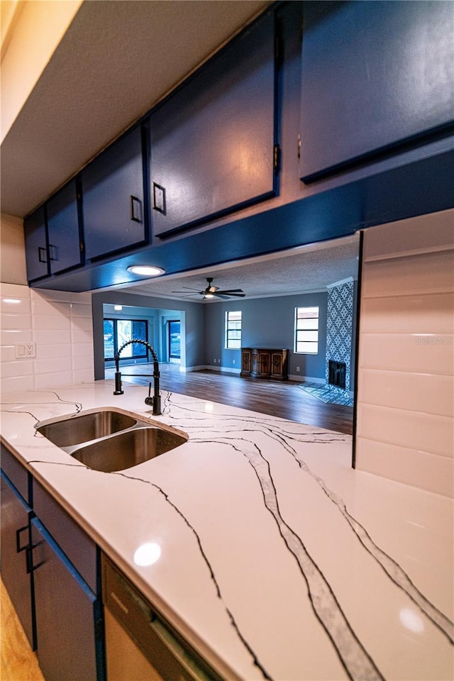 kitchen featuring hardwood / wood-style floors, backsplash, ceiling fan, and sink