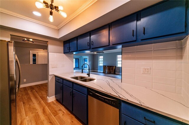 kitchen with decorative backsplash, stainless steel appliances, crown molding, sink, and blue cabinetry