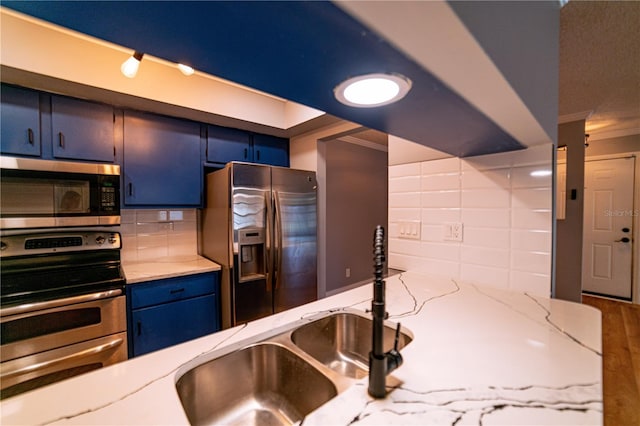 kitchen featuring blue cabinetry, sink, stainless steel appliances, tasteful backsplash, and ornamental molding