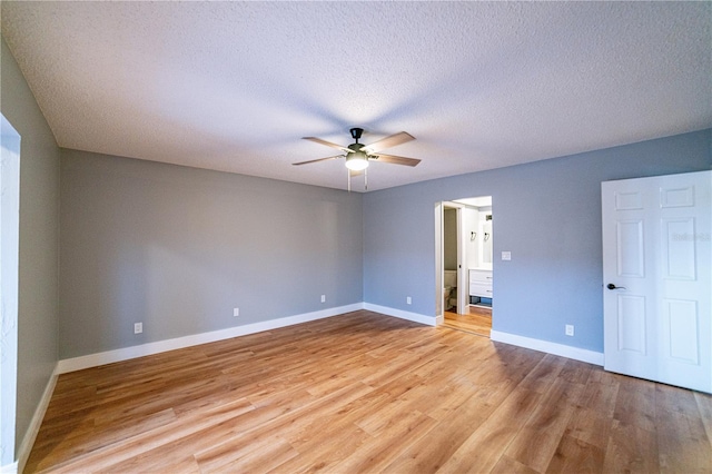 spare room featuring ceiling fan, light hardwood / wood-style floors, and a textured ceiling