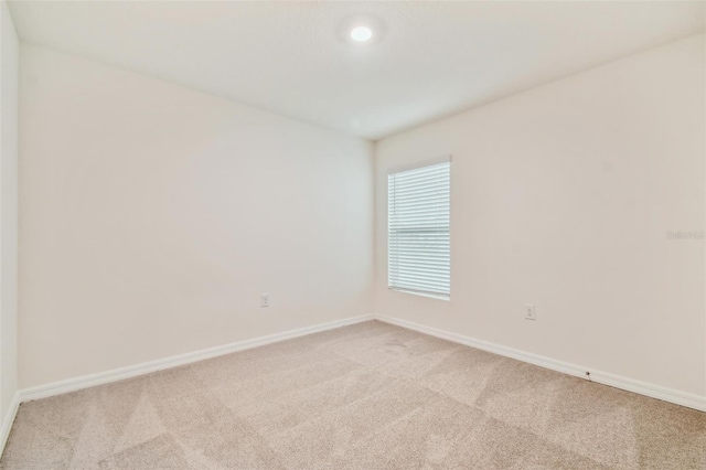 unfurnished room featuring light carpet