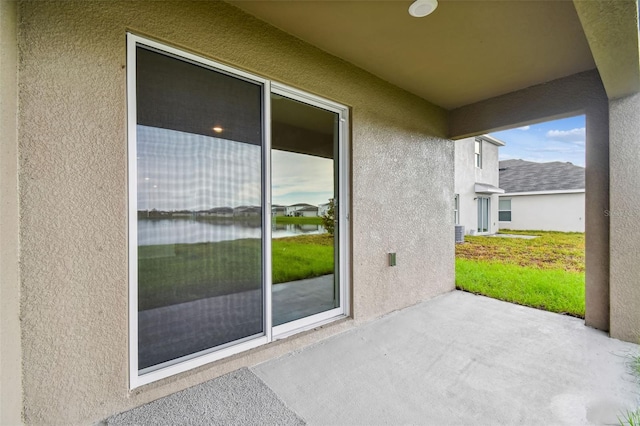 view of patio / terrace featuring cooling unit and a water view