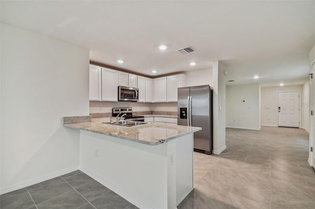 5552 Logan Cave Ave, Wimauma, FL 33598 - kitchen with a sink, stainless steel appliances, a peninsula, white cabinetry, and visible vents