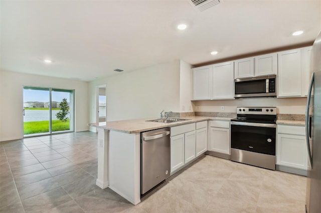 kitchen with kitchen peninsula, white cabinetry, sink, and appliances with stainless steel finishes