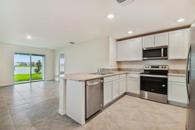 5552 Logan Cave Ave, Wimauma, FL 33598 - kitchen with white cabinets, stainless steel appliances, visible vents, a sink, and a peninsula