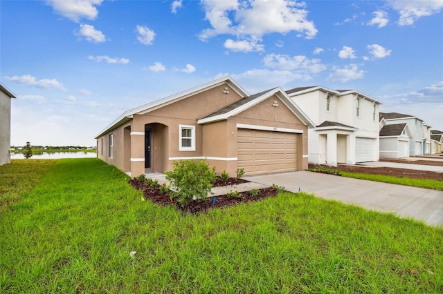 ranch-style home featuring a garage, a water view, and a front lawn