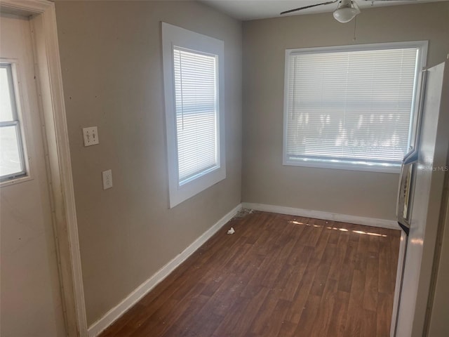 empty room with ceiling fan and dark wood-type flooring