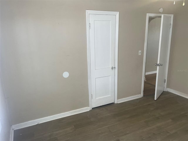 unfurnished bedroom with dark hardwood / wood-style flooring