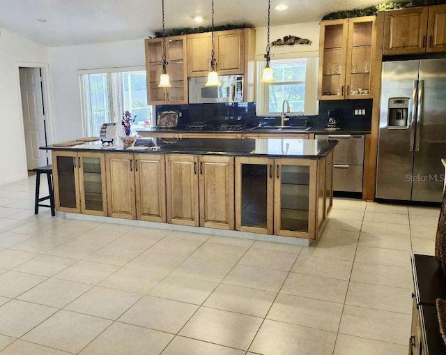 kitchen with plenty of natural light, a center island, sink, and stainless steel appliances