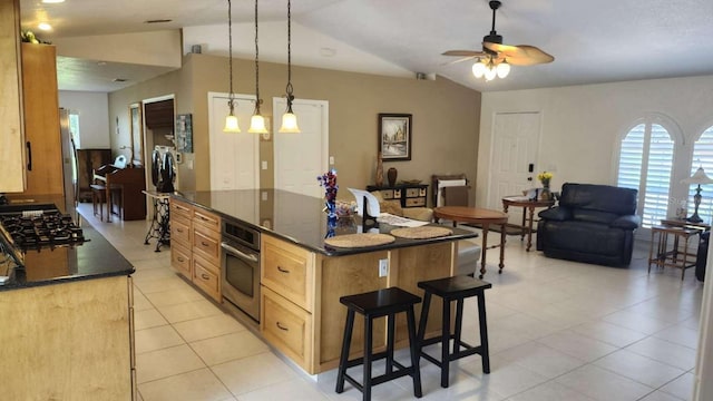 kitchen with a kitchen island, lofted ceiling, hanging light fixtures, ceiling fan, and stainless steel appliances