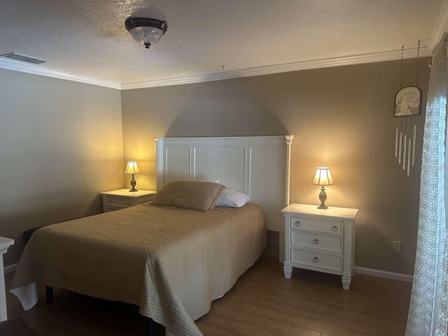 bedroom featuring hardwood / wood-style flooring, ornamental molding, and a textured ceiling