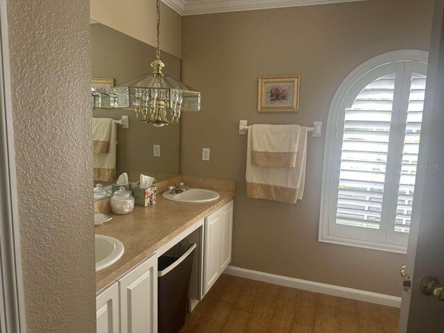 bathroom with a chandelier, wood-type flooring, double sink vanity, and crown molding