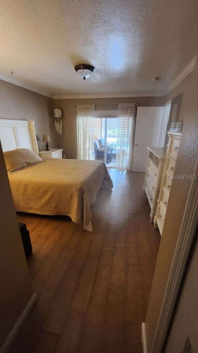 bedroom featuring dark wood-type flooring, access to outside, crown molding, and a textured ceiling