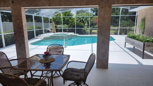 view of swimming pool with a patio, an in ground hot tub, and a lanai