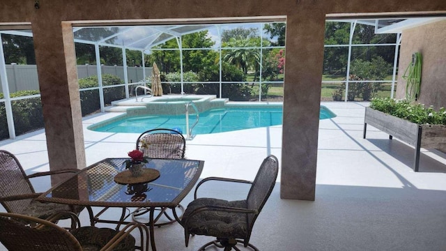 view of pool with an in ground hot tub, glass enclosure, and a patio area