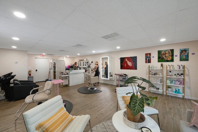 living room featuring a drop ceiling and wood-type flooring