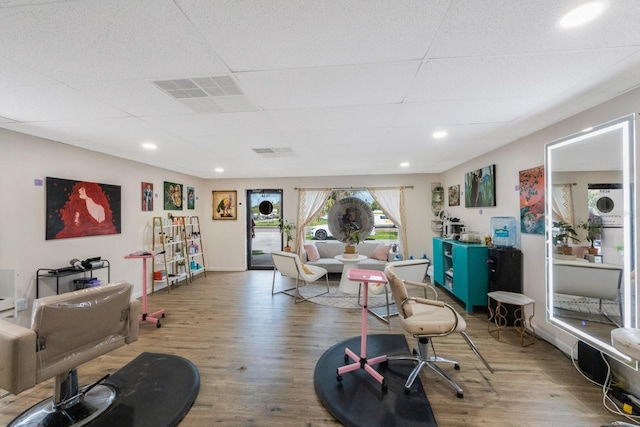 living room with wood-type flooring and a drop ceiling