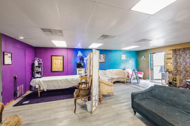 bedroom featuring hardwood / wood-style floors, white refrigerator, and a drop ceiling