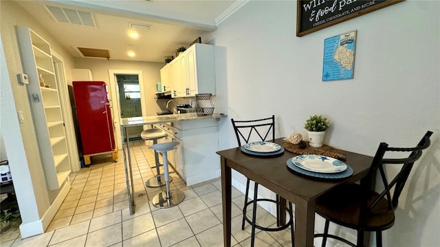 tiled dining space with sink and ornamental molding